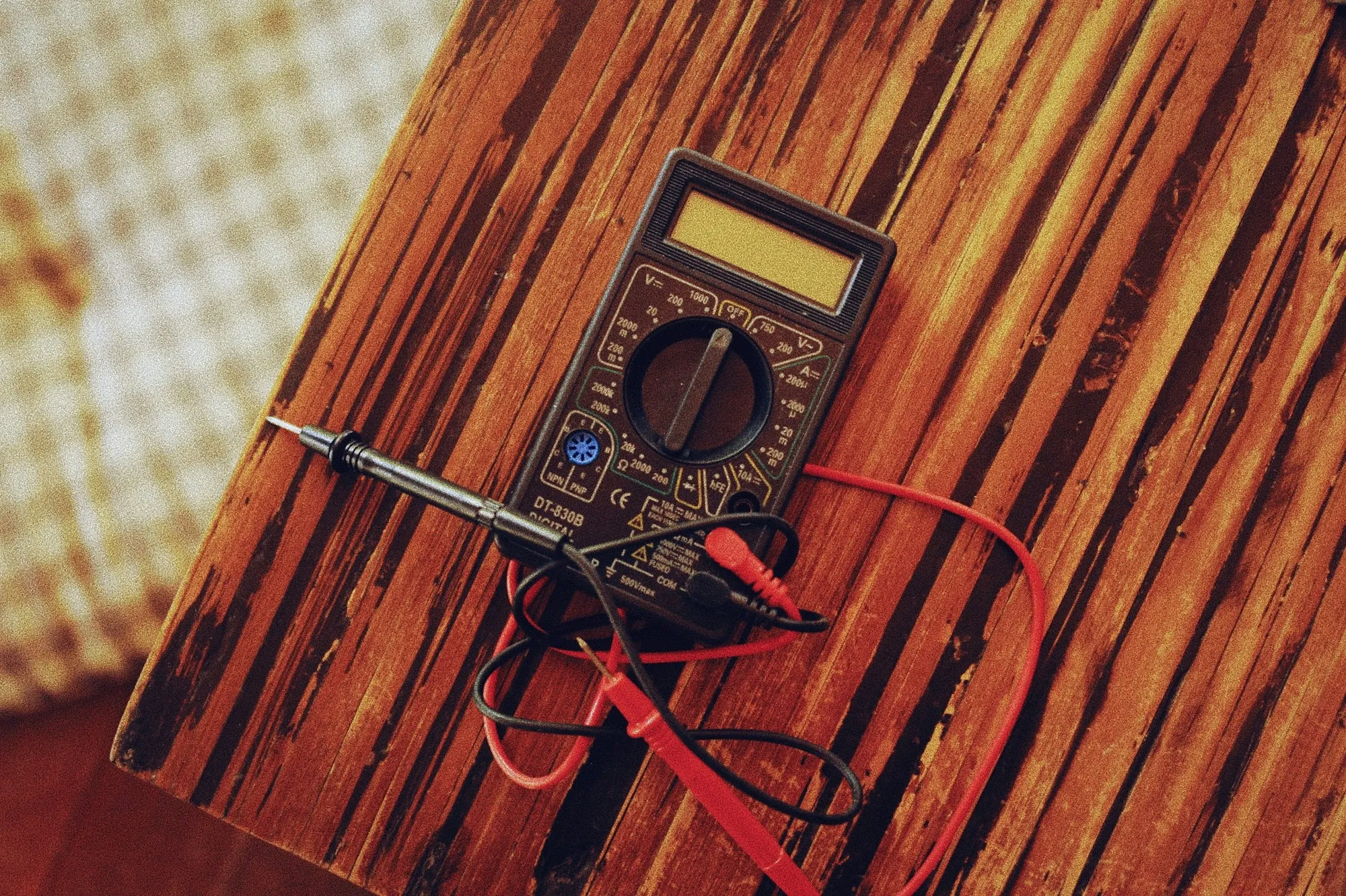 Multimeter and probes lying on a wood surface